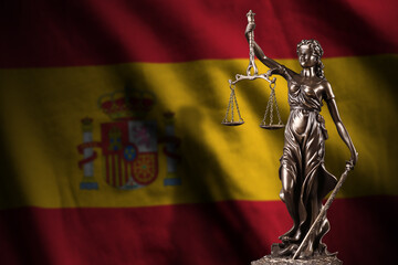 Spain flag with statue of lady justice and judicial scales in dark room. Concept of judgement and...