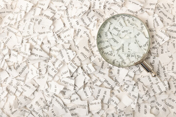 Magnifying glass on scraps of notes background.