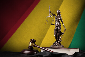 Guinea flag with statue of lady justice, constitution and judge hammer on black drapery. Concept of...