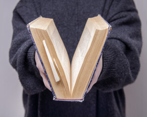 the girl hands are holding an old book . selective focus.High quality photo