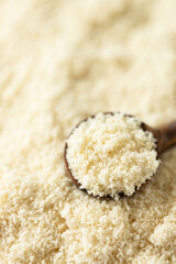 Almond flour in wooden spoon.