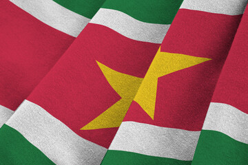 Suriname flag with big folds waving close up under the studio light indoors. The official symbols...