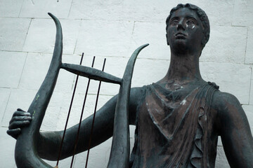 Statue of Greek goddess of inspiration. Sculpture made of metal.