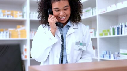 Happy black pharmacist answering a phone in a pharmacy, checking stock, doing inventory and assisting patients with their prescriptions. Modern no contact dispensary with a health care professional