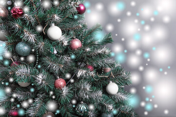 Christmas tree with branches sprinkled with hoarfrost and elegantly decorated with Christmas balls, beads, garlands.Horizontal, closeup