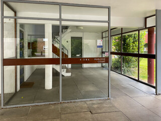 An elegant glass-framed entrance to flats at Parkleys a 1950s private low-rise Modernist housing estate in Ham, South-West London, near Richmond. Designed by Eric Lyons, built by SPAN Developments. 