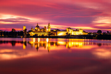 Fototapeta premium Panoramic evening view of Mantua, Lombardy, Italy; scenic twilight skyline view of the medieval town reflected in the lake waters