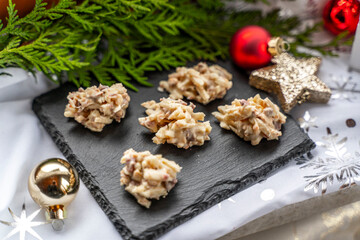 Almond slivers with white chocolate on a slate with Christmas decorations