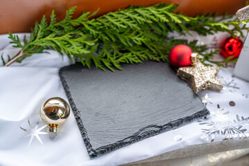 Schieferplatte mit roter und goldener Dekoration für Weihnachten