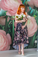 girl with a bouquet of magnolias. the girl covers her Breasts with flowers. red-haired girl