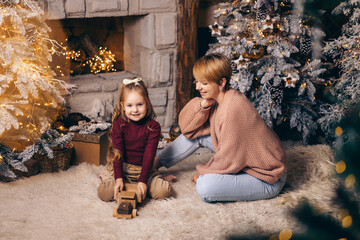 Mom and daughter in a decorated Christmas living room at home