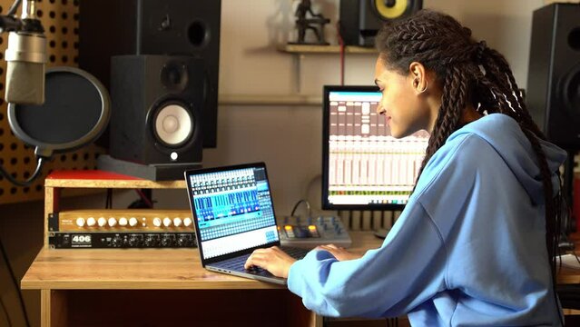 Sound engineer using control desk recording new track for album in soundproof room of music studio