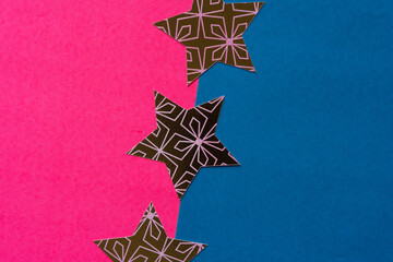 paper stars on pink and blue paper background