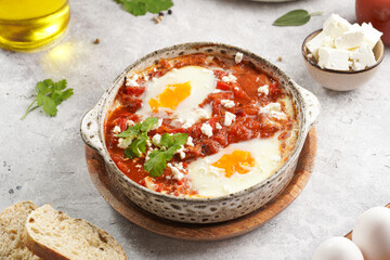 Traditional north african dish shakshouka made of eggs poached in a sauce of tomatoes, olive oil,...