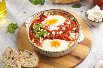 Traditional north african dish shakshouka made of eggs poached in a sauce of tomatoes, olive oil, bell peppers, onion and garlic, spiced with cumin, paprika and cayenne pepper