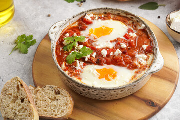 Traditional north african dish shakshouka made of eggs poached in a sauce of tomatoes, olive oil, bell peppers, onion and garlic, spiced with cumin, paprika and cayenne pepper