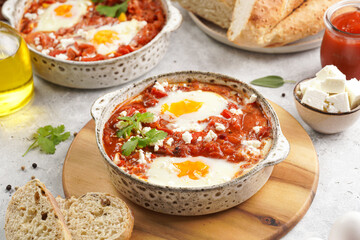 Traditional north african dish shakshouka made of eggs poached in a sauce of tomatoes, olive oil, bell peppers, onion and garlic, spiced with cumin, paprika and cayenne pepper