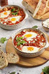 Traditional north african dish shakshouka made of eggs poached in a sauce of tomatoes, olive oil, bell peppers, onion and garlic, spiced with cumin, paprika and cayenne pepper