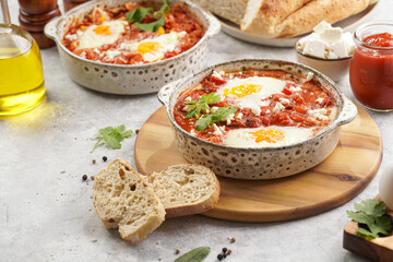 Traditional north african dish shakshouka made of eggs poached in a sauce of tomatoes, olive oil, bell peppers, onion and garlic, spiced with cumin, paprika and cayenne pepper