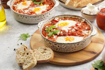 Traditional north african dish shakshouka made of eggs poached in a sauce of tomatoes, olive oil, bell peppers, onion and garlic, spiced with cumin, paprika and cayenne pepper
