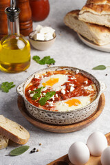 Traditional north african dish shakshouka made of eggs poached in a sauce of tomatoes, olive oil, bell peppers, onion and garlic, spiced with cumin, paprika and cayenne pepper