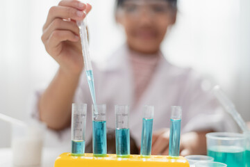 education, science, chemistry and children concept - kids or students with test tube making experiment at school laboratory