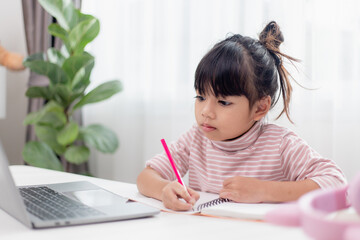 Asian little girl at home doing homework