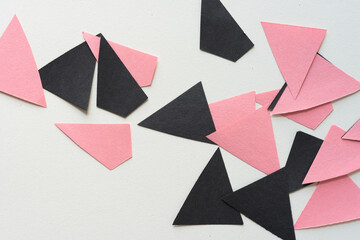 rough black and pink paper triangles and polygons on blank paper