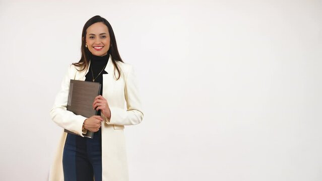 nice-looking young businesswoman psoing for the camera with paperwork in a hand, medium-full shot white background copy space. High quality 4k footage