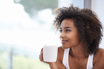 The soothing smell of fresh morning coffee. Cropped shot of a young woman enjoying a cup of coffee.