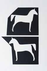 stylized paper horses (glyph cutouts) on blank paper
