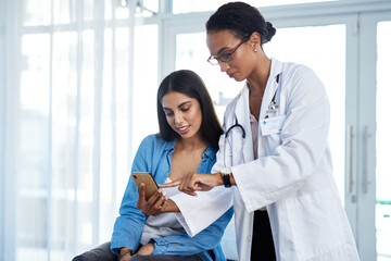 Ill send you some helpful health tips to you. Shot of a young doctor using a smartphone during a...