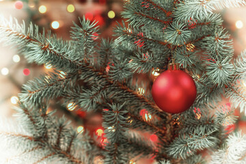 Red Ornament hanging from tree with glowing lights in vinatage format