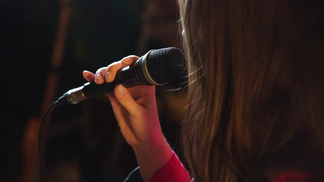 Close up woman singing with a microphone. High quality 4k footage