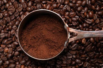Pot with ground coffee on roasted beans, top view