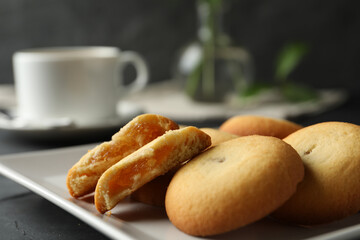Tasty shortbread cookies with filling on black table, closeup