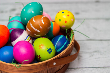 Fototapeta na wymiar Basket with painted colorful easter eggs