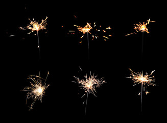 Fototapeta premium Collage with bright burning sparklers on black background