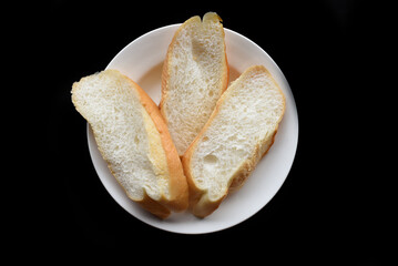 Sliced Vietnamese traditional Banh Mi baguette on black background