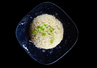 Plate with white rice, serving for Vietnamese dishes on black background