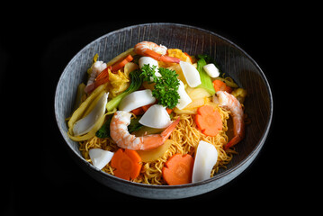 Seafood with noodles in a bowl isolated on black background side view