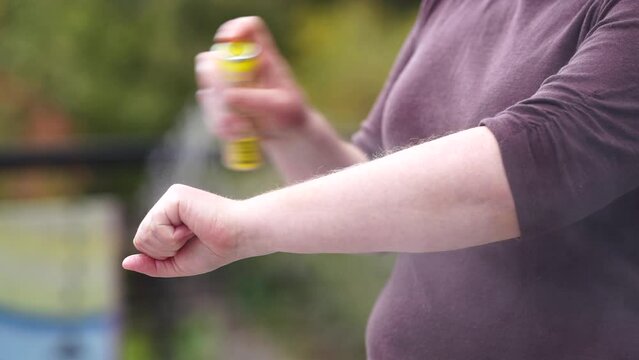woman applying bug spray, girl spraying on bug spray 