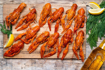 beer and beautiful boiled crayfish on a wooden table and wooden board with dill and lemon