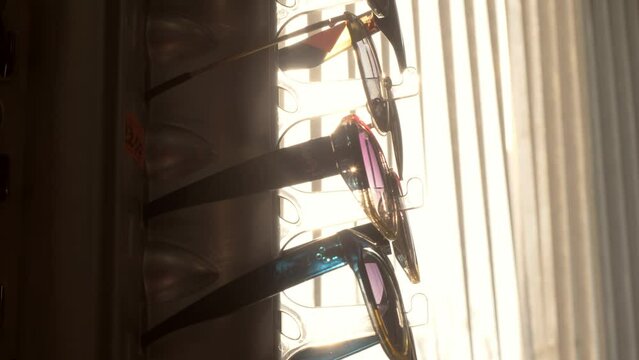 row of various types of sunglasses on display in an optical shop