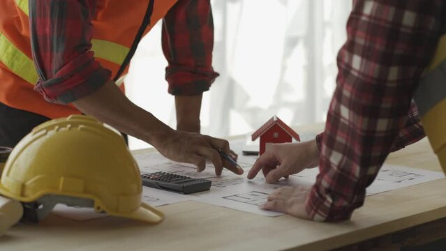 Two caucasian architects working on a project at the designer's office looking at building plans Engineer or Architect or Technician The contractor is looking at the construction drawings of the proje