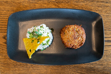 potato pancake draniki and white sour cream sauce on plate. veggie fritters vegetarian pancakes...