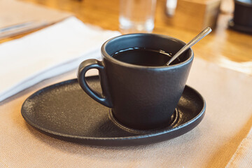 Black tea cup saucer for drink. Ceramic coffee cup or mug close up.