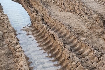 puddle Wet ground tireprint, Car tire tracks footprint on construction site
