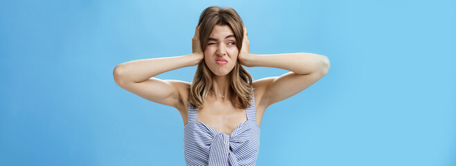 Girl feeling irritated by loud awful noise pressing hands to ears not hear annoying sound of drill...
