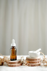 Obraz na płótnie Canvas skincare serum with natural wooden stand and small pestle and mortar on white background.